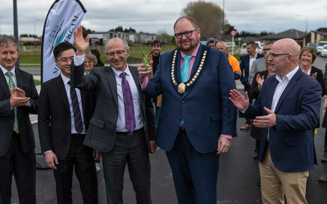 VIPs applauding the cutting of the ribbon at the opening of Silverstream Boulevard