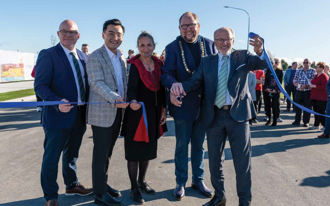 five people hold the ribbon after the ribbon cutting ceremony