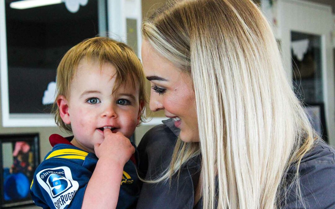 Teacher at Beststart Preschool holding young boy