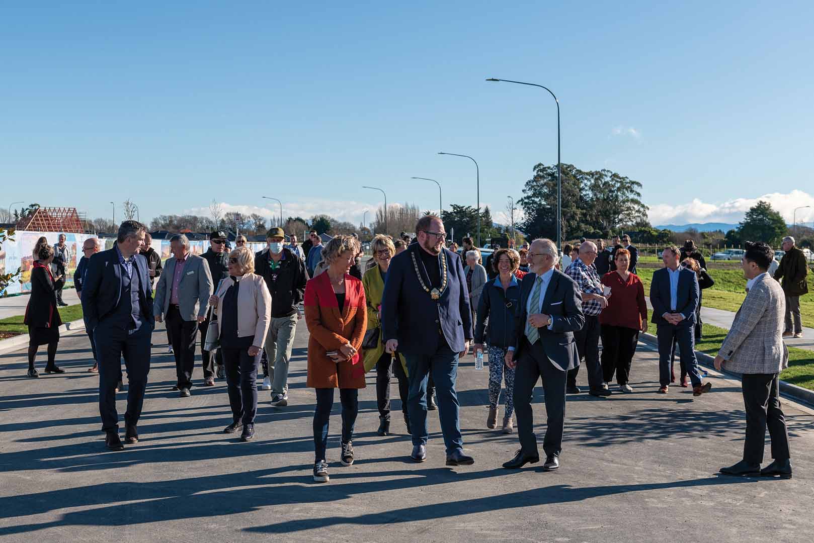 a large group of people wandering and talking at the opening of Silverstream Boulevard