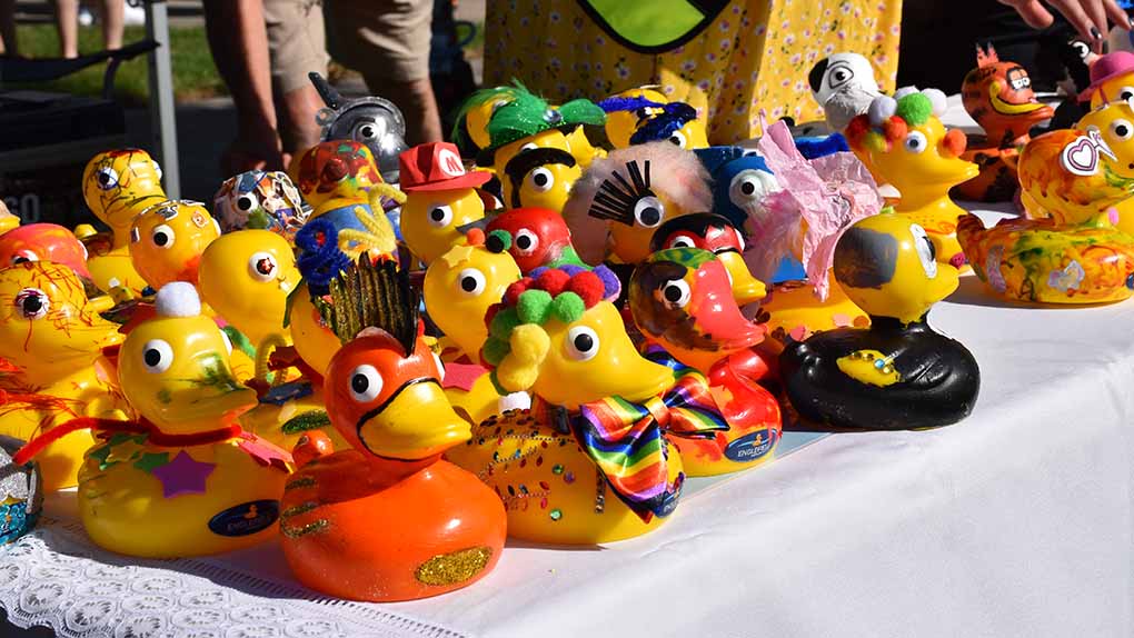 decorated yellow plastic ducks displayed on a table