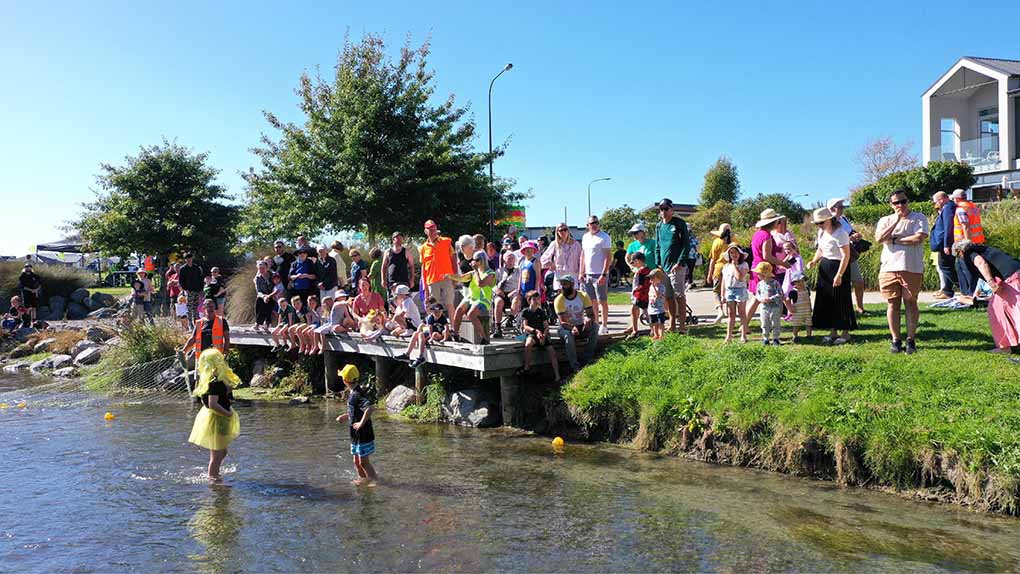 Image of community on Silverstream jetty watching the finish line of the duck race