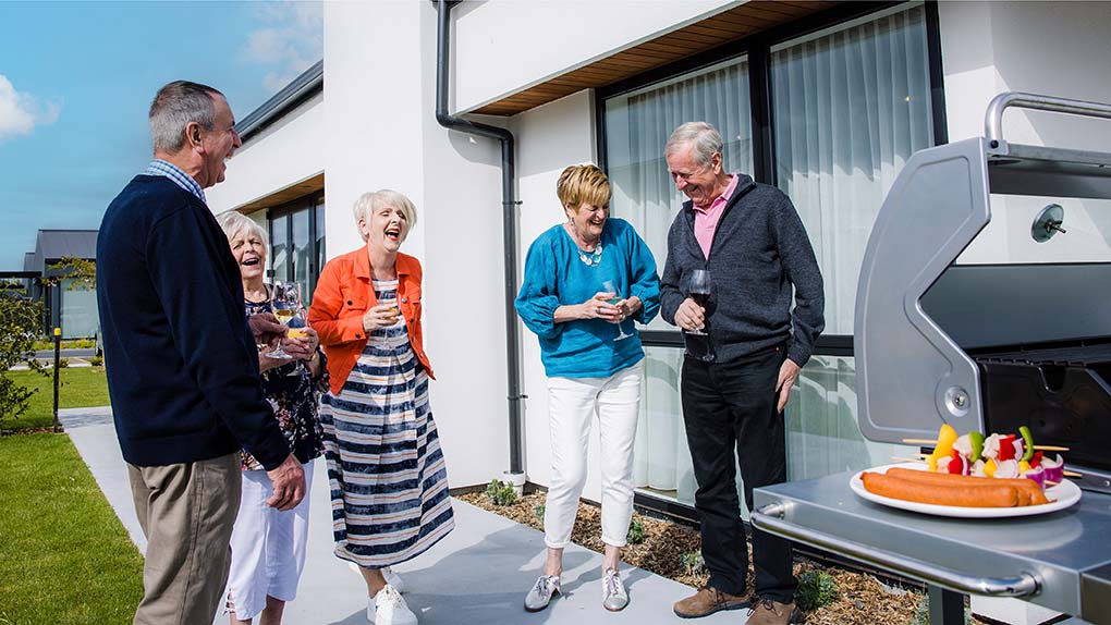 Retired friends laughing around a barbeque