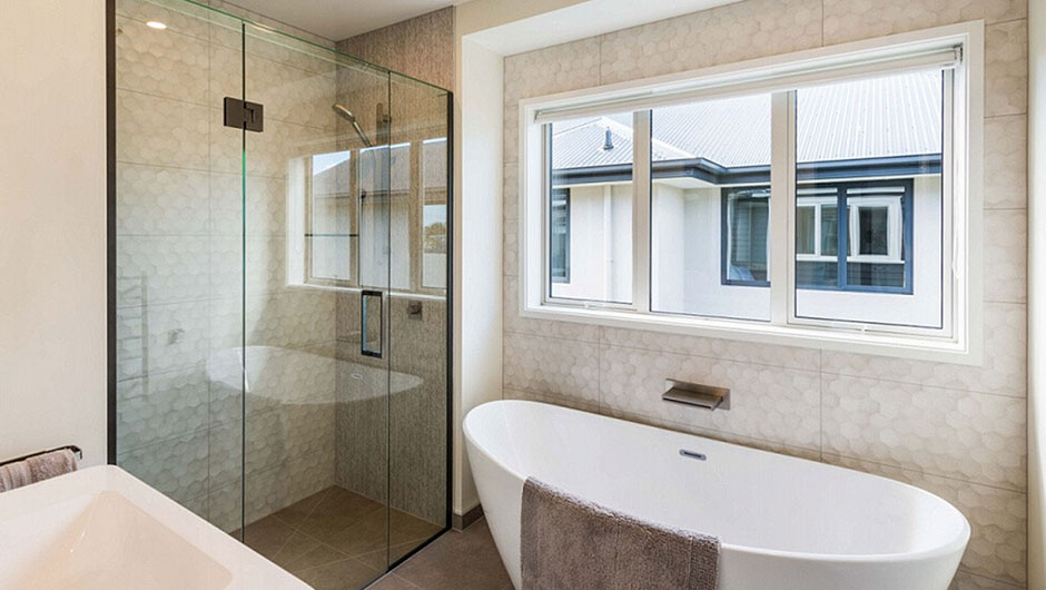 modern tiled bathroom with free standing bath and walk in shower