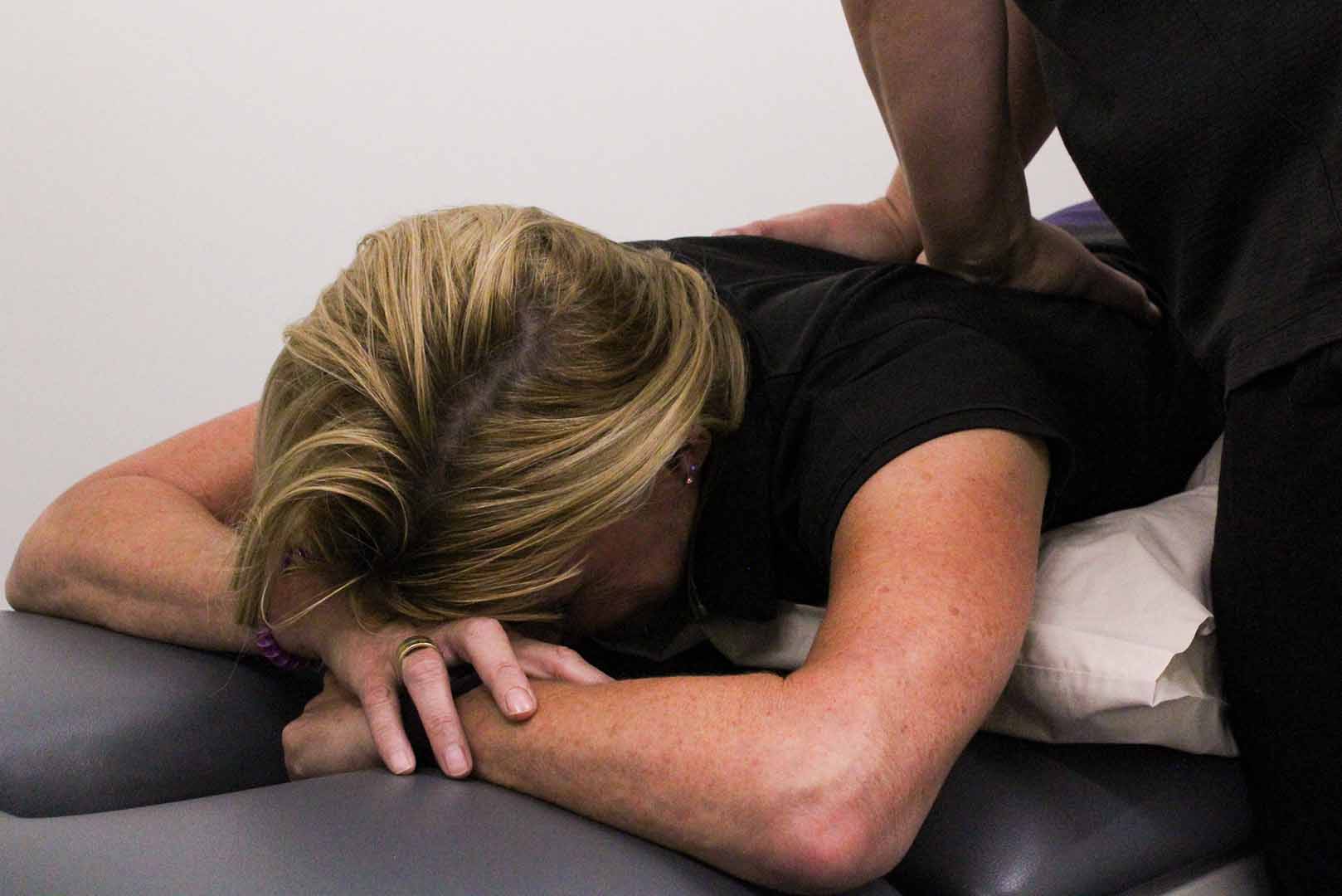 a physiotherapist giving a woman a back massage