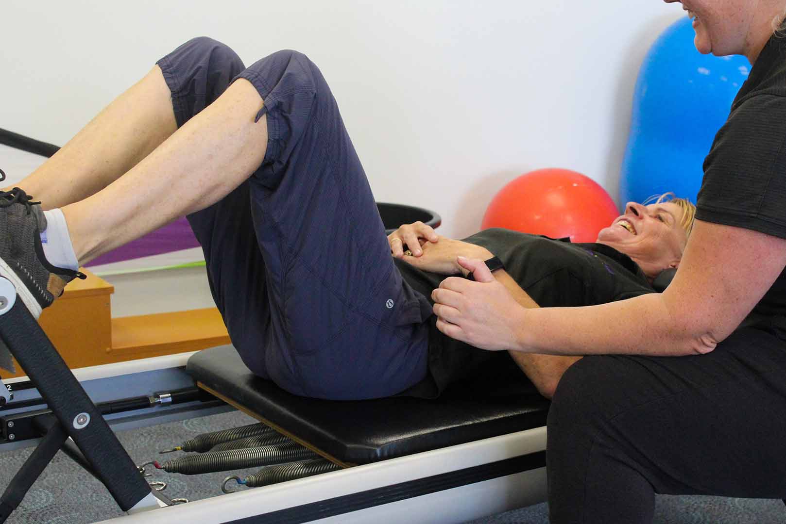 a woman lying on a physio machine strengthening leg and core muscles