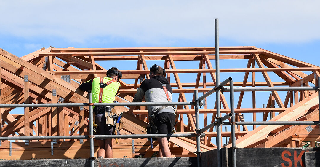 Image of two builders working on the roof truss of a home under construction in Silverstream subdivision.