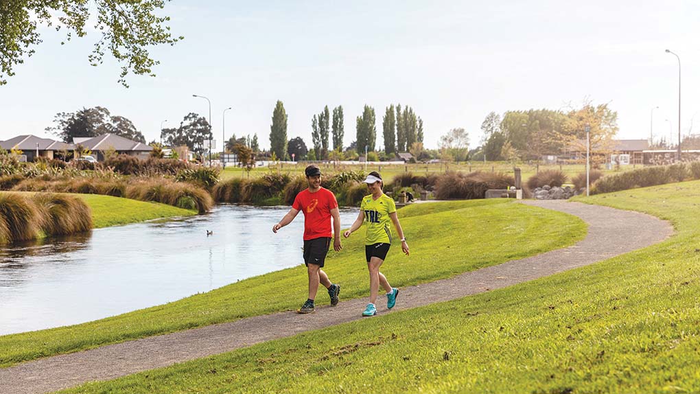 young couple walking on pathway next to Silverstream river