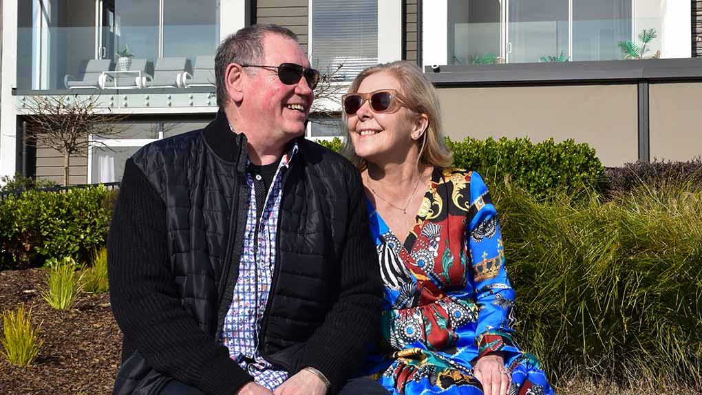 couple relaxing outdoors in front of modern home